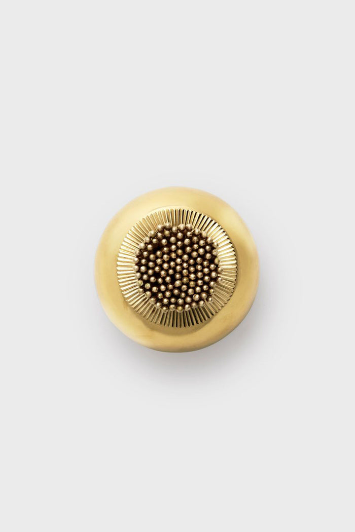 Sphere Match Striker: A classic, high-end brass piece with a sunburst band and central cluster, effortlessly blending form and function for a fun yet refined decor accent.