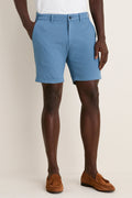 Classic Storm Andrews Flat-Front Short in light blue, worn with white T-shirt and brown loafers. Effortless style for fun, high-end warm-weather adventures.