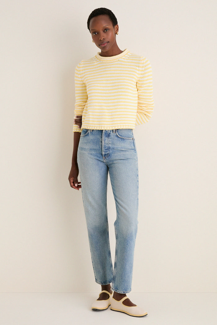 Person wearing the classic Sunshine and Cream Fine Stripe Mini Marina Sweater with high-waisted jeans and Mary Jane flats exudes effortless, high-end style with a fun, cozy vibe.