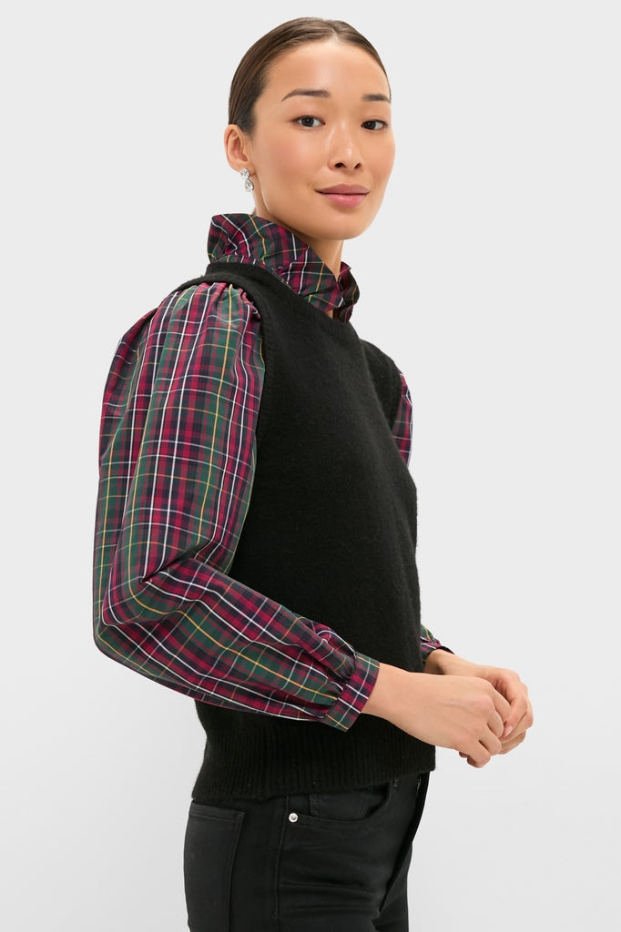 Model wearing the Tartan Ella Sweater Blouse, a sleeveless black knit vest over a tartan shirt, embodying a classic, effortless style for festive, high-end holiday events.