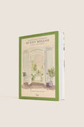 The Enchanting Interiors of Bunny Mellon, a classic hardcover with a watercolor doorway, offers an effortless glimpse into high-end interiors, blending fun and sophistication.