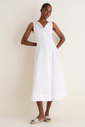 A slim woman models a White Cotton Boat Neck Dress, exuding effortless elegance with its classic sleeveless design, ideal for high-end, fun, warm-weather styling.