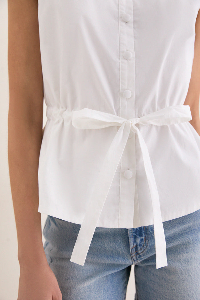 Classic and effortless, the White Cotton Poplin Francoise Top offers high-end sophistication with a high neckline, sleeveless cut, and self-tie waist for everyday fun.