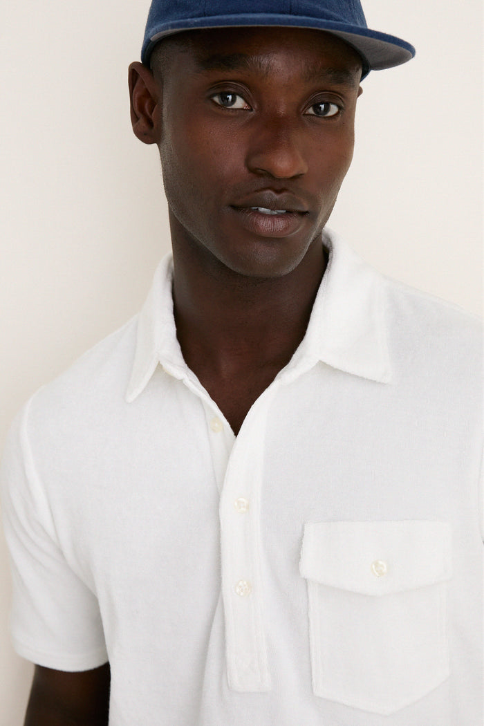 Young man models the classic White Lotus Terrycloth Players Shirt with a 4-button placket, embodying effortless, high-end style perfect for any fun adventure.